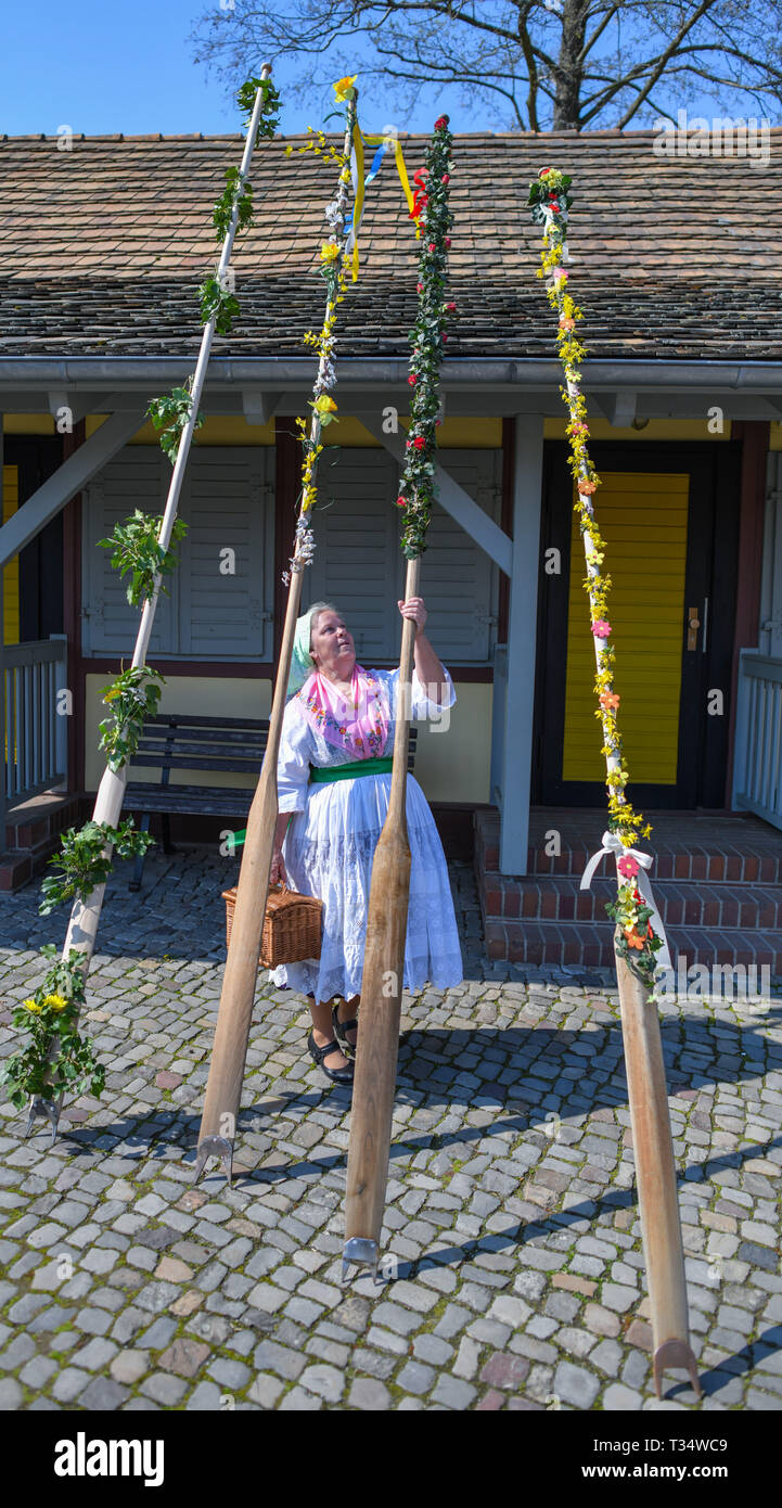 Brandenburg, Lübbenau, Germany. 6th April, 2019. A woman in a Sorbian-Wendish festive costume looks at a herd decorated to punt a barge for the opening of this year's Spreewald season. On the same day, the new season was ceremoniously opened with the handing over of a pack (rowing bar) at the Spreewaldhafen in Lübbenau. About 1000 kilometres of river run through the Spreewald in the southeast of Brandenburg. Photo: Patrick Pleul/dpa-Zentralbild/dpa Credit: dpa picture alliance/Alamy Live News Credit: dpa picture alliance/Alamy Live News Stock Photo