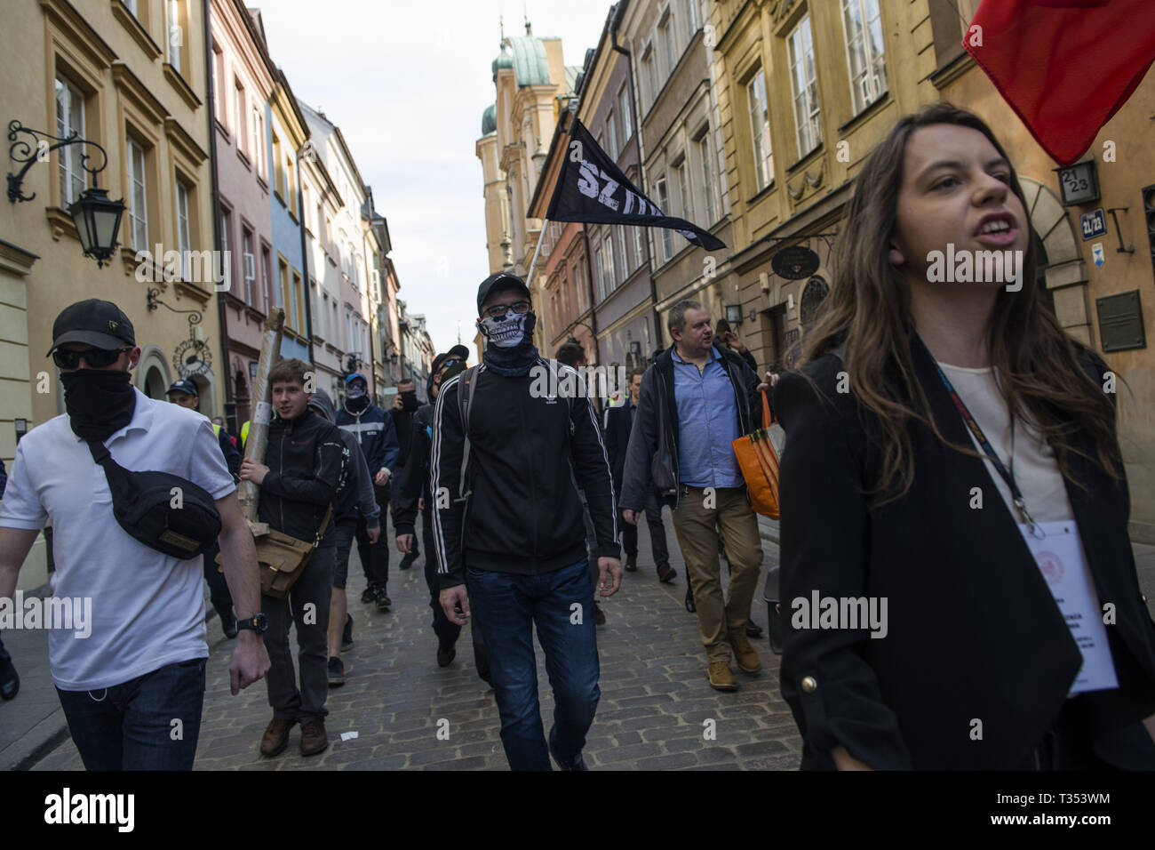 April 6, 2019 - Warsaw, Mazowieckie, Poland - Nationalists seen with flags and masks marching through the streets surrounded by police forces during the protest.''Universities free from Marxism'' a protest against the Warsaw University to express their opposition to the activity of leftist extremists and other cases of left-wing indoctrination of Polish students. In the same place, students, leftist and anti-fascist activists gathered under the slogan ''Here we learn, do not heil''. Both groups were separated by a large police cordon. (Credit Image: © Attila Husejnow/SOPA Images via ZUMA Wire Stock Photo