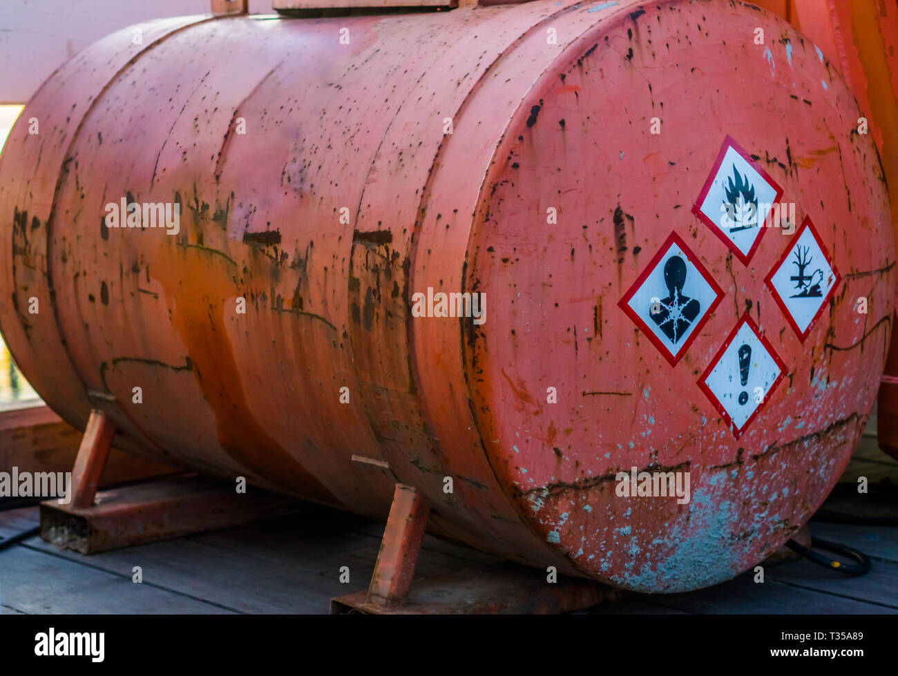 old rusty silo tank containing hazardous substances, warning labels on the side, storage of