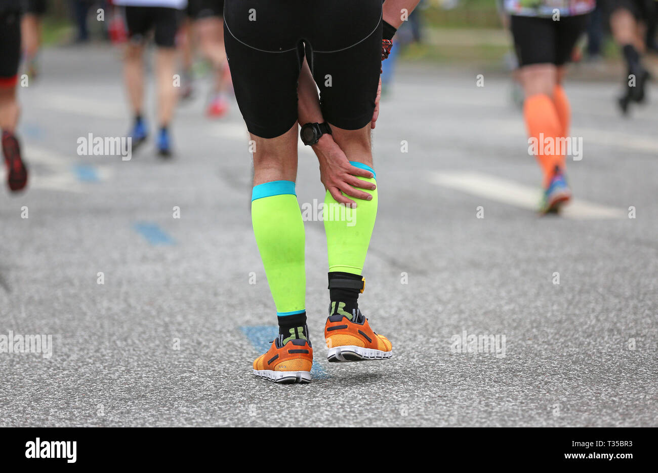 marathon runner feels pain in his calf Stock Photo