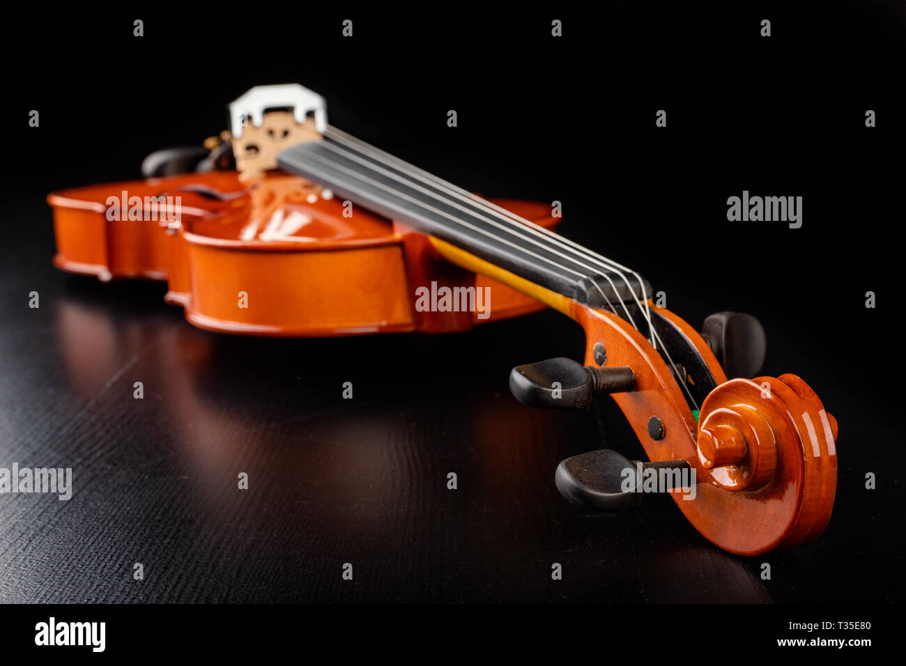 Beautiful new shiny violin on a dark table. Musical string instrument ...