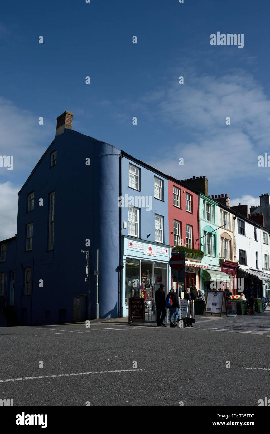 Multi coloured shops and pedestrians in castle square Caernarfon north wales uk Stock Photo