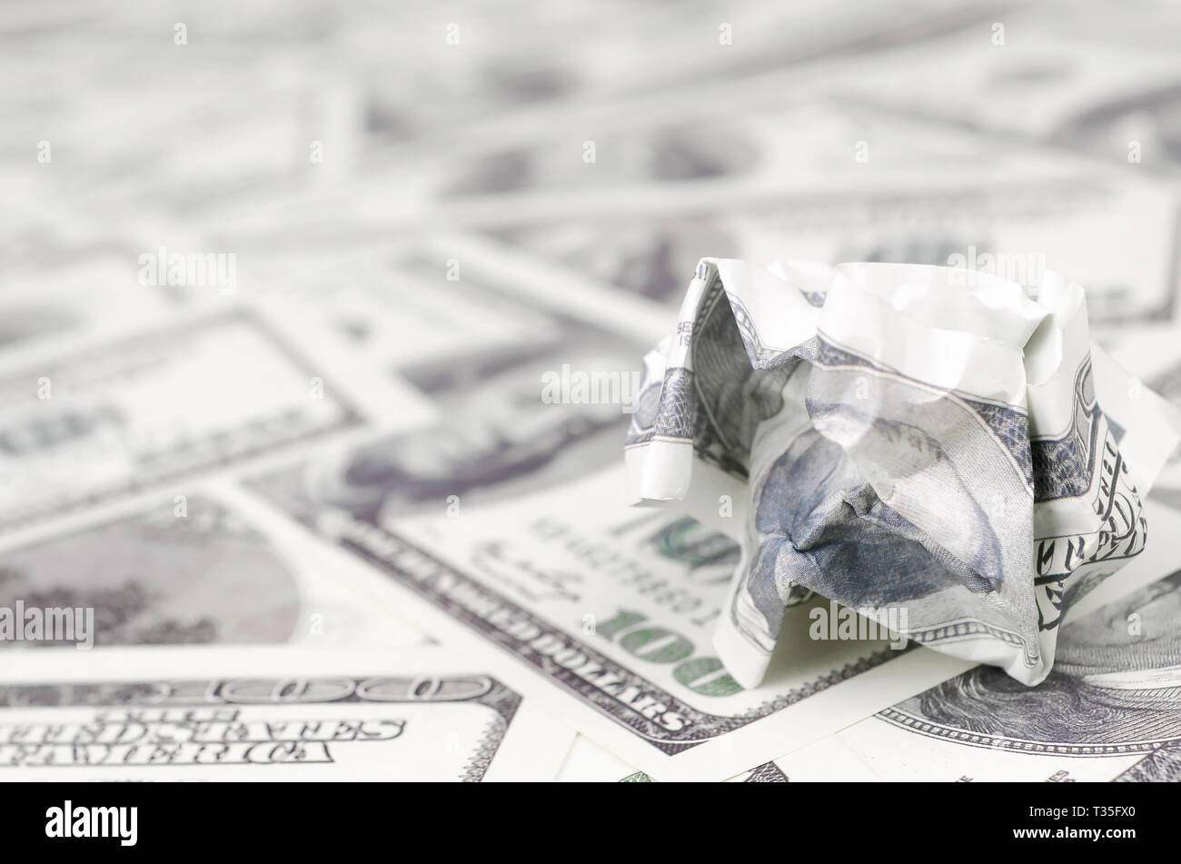 Crumpled dollar bill of the United States lies on the set of smooth money bills. Concept of unreasonable waste of money Stock Photo