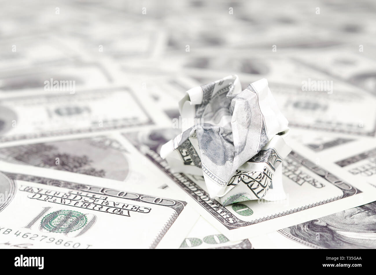 Crumpled dollar bill of the United States lies on the set of smooth money bills. Concept of unreasonable waste of money Stock Photo