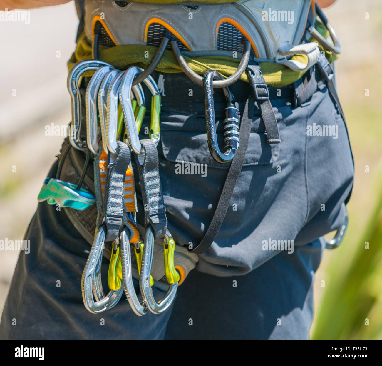 Mountaineering safety equipment hanging on harness closeup, ready to