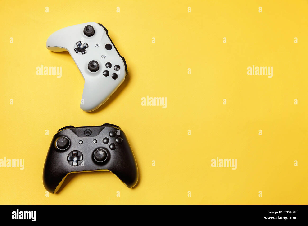 White and black two joystick gamepad, game console on yellow colourful ...