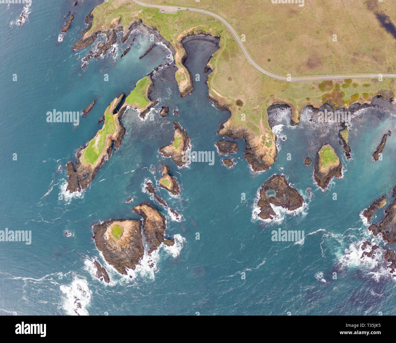 The cold waters of the Pacific Ocean wash against the scenic and rugged