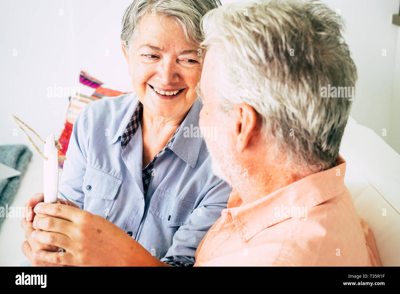 Nice beautiful caucasian senior woman cheerful smiling at  the man sitting with her - relationship and no limit age to flirt or be happy together - lo Stock Photo