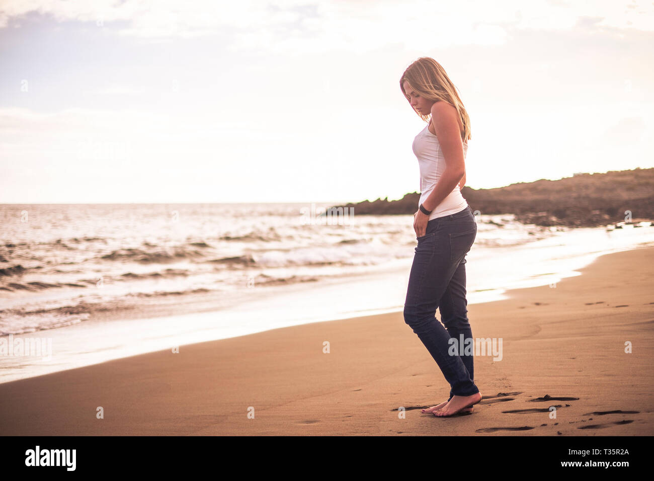 Two alluring women are relaxing on the nudist beach