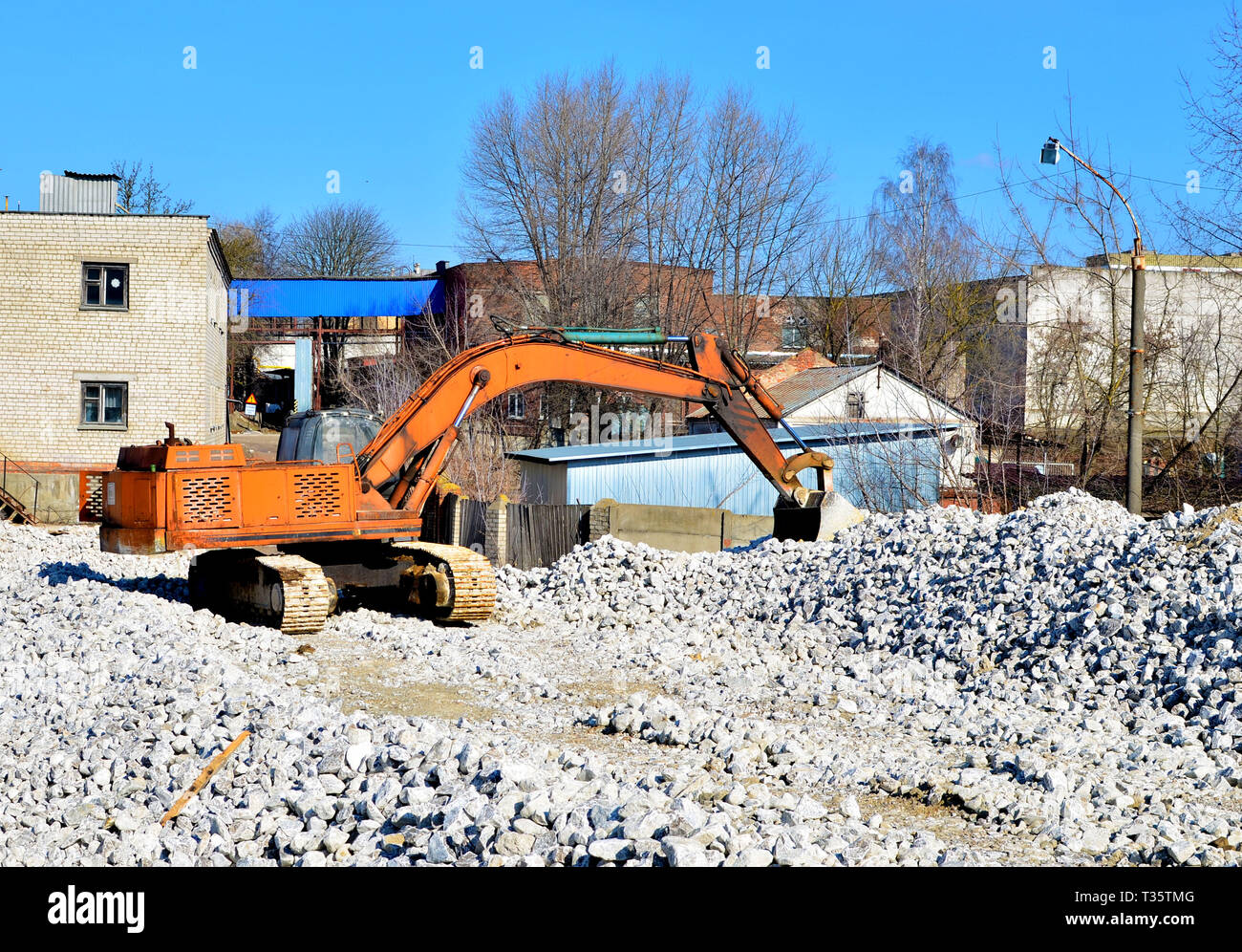 Construction excavator at an industrial gypsum stone processing plant. Excavator bucket loads
