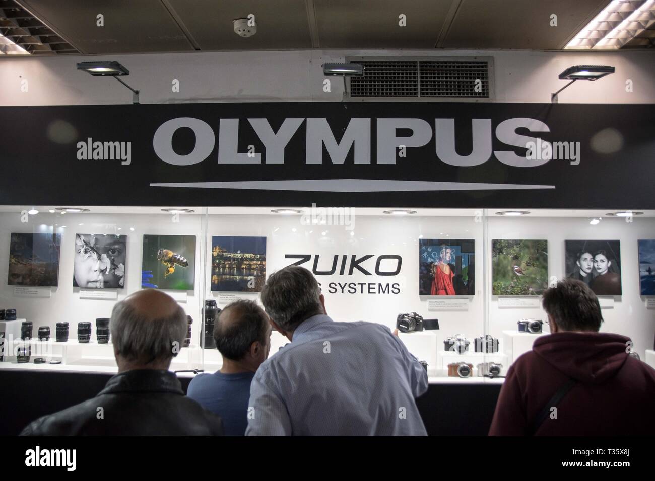 People are seen looking on at the Olympus new technologies systems during the festival. Image +Tech & Photo vision 2019 is a big festival with large corporate delegations, many exhibitions, stores and workshops about photography and video was held In the place of Helexpo Marousi in Athens, Greece. Stock Photo
