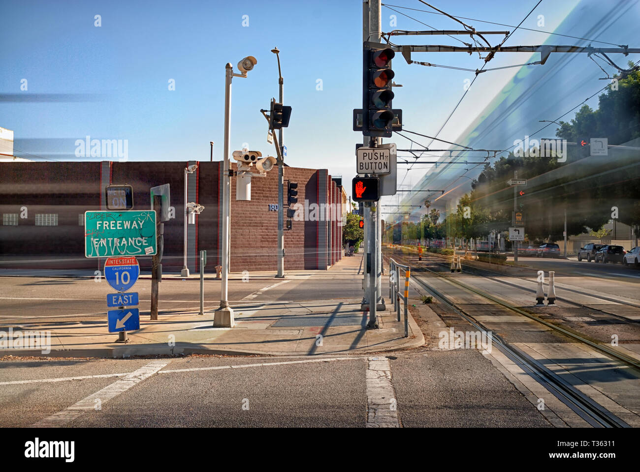Flower Street, an on ramp to the 10 freeway, an the light rail metro speeding by. Stock Photo