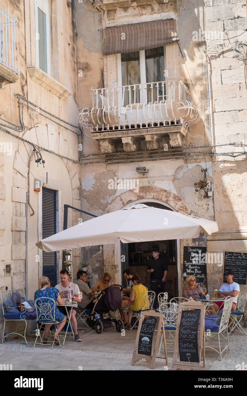 Cafe culture - locals and tourists dining at Cafe  on via Della Maestranza in Ortigia, Sicily, Italy Stock Photo