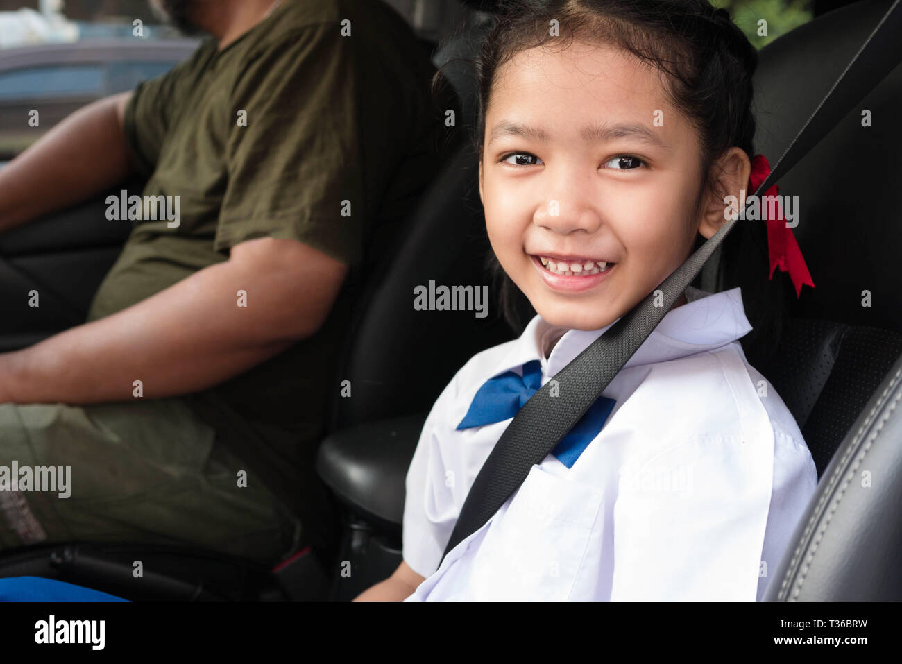 Asian Girl Wear Uniform Sit In The Car And Fasten The Belt For Safety