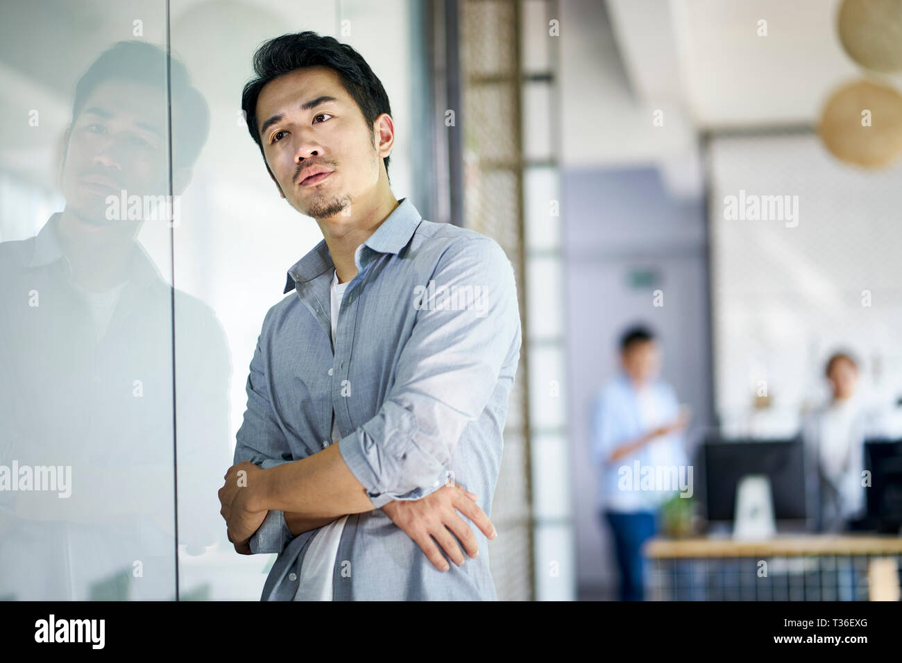 young asian entrepreneur or designer thinking in company office. Stock Photo