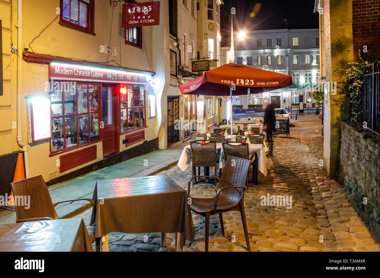 Table and chairs setup for outside dining in front of restaurants in Church Lane, Windsor, UK at night. Stock Photo
