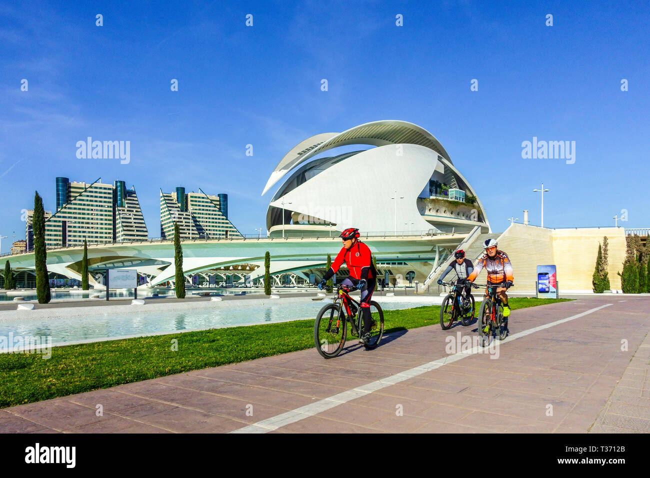 Spain Valencia City of Arts and Sciences, bikers on bicycles, Valencia Turia Park People cycling in a modern contemporary place Bike lane Stock Photo