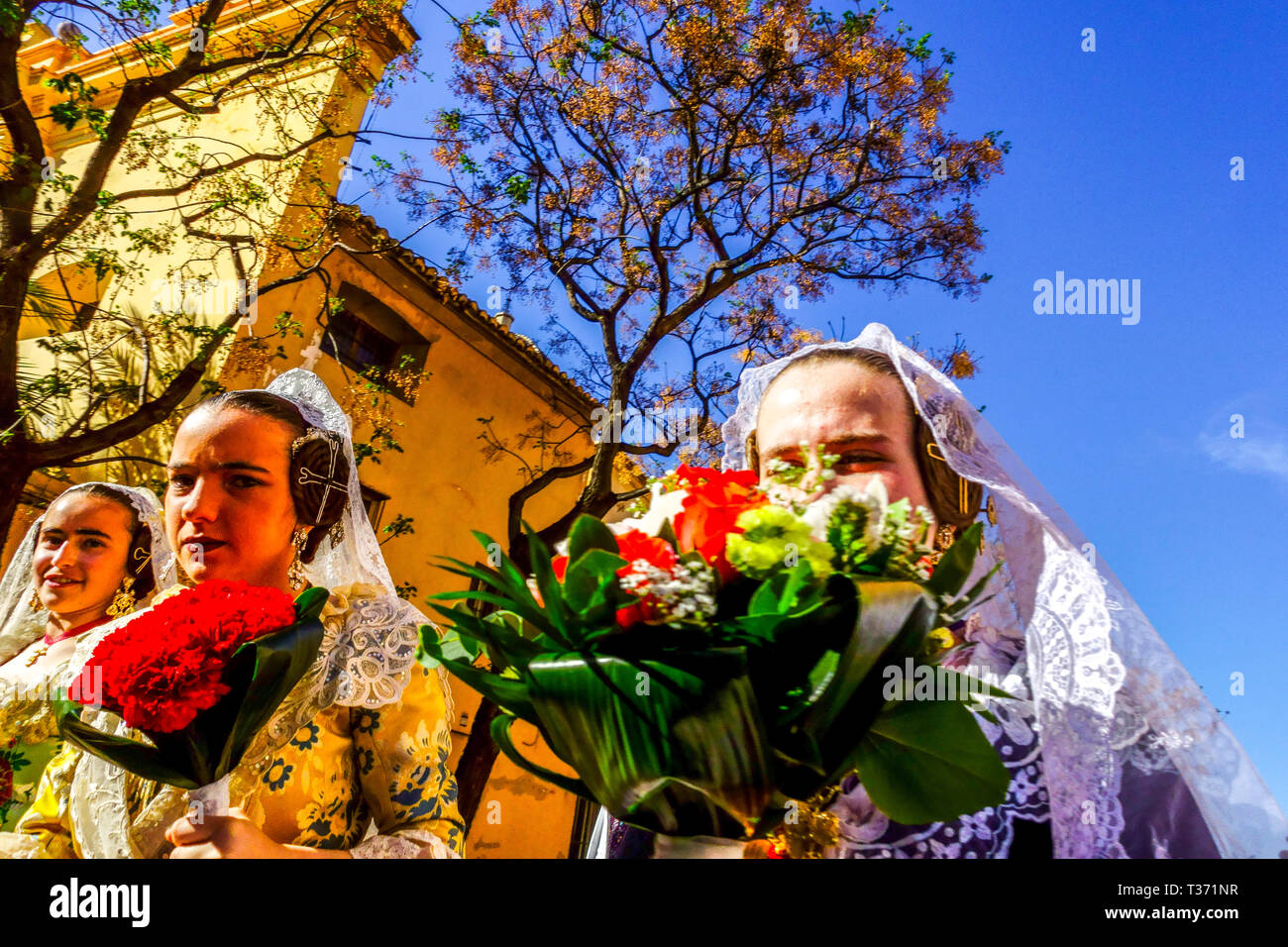 Valencia Fallas festival, young Spanish women marching trough city with flowers in traditional costumes, Spain Las Fallas Valencia Spain  Europe Stock Photo