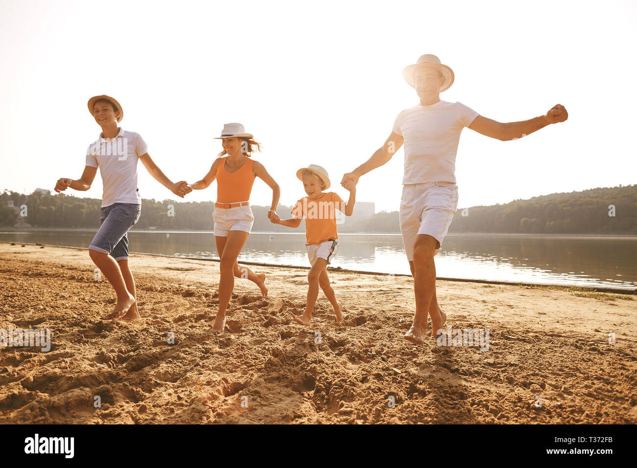 Happy family running on beach hi-res stock photography and images - Alamy