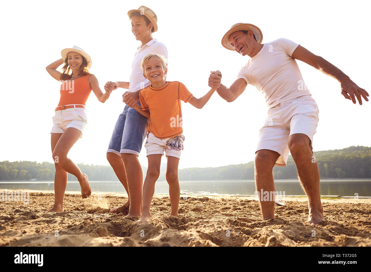 Happy family on beach playing hi-res stock photography and images - Alamy