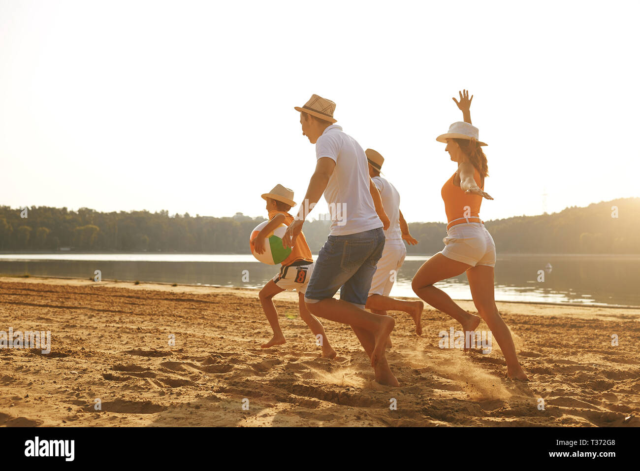 Happy family running on beach hi-res stock photography and images - Alamy