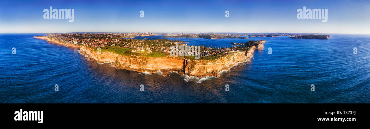 Edge of Australian continental plateau at Pacific ocean in view of Sydney Eastern Suburbs and distant city CBD behind Sydney Harbour in wide aerial pa Stock Photo
