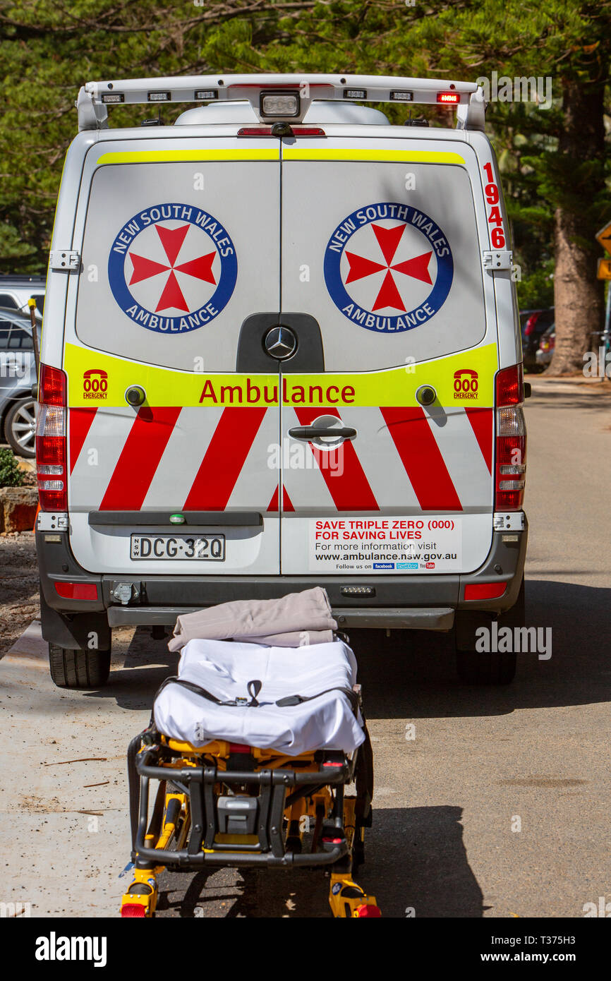 New South Wales ambulance at the beach with stretcher awaiting a patient being moved from the