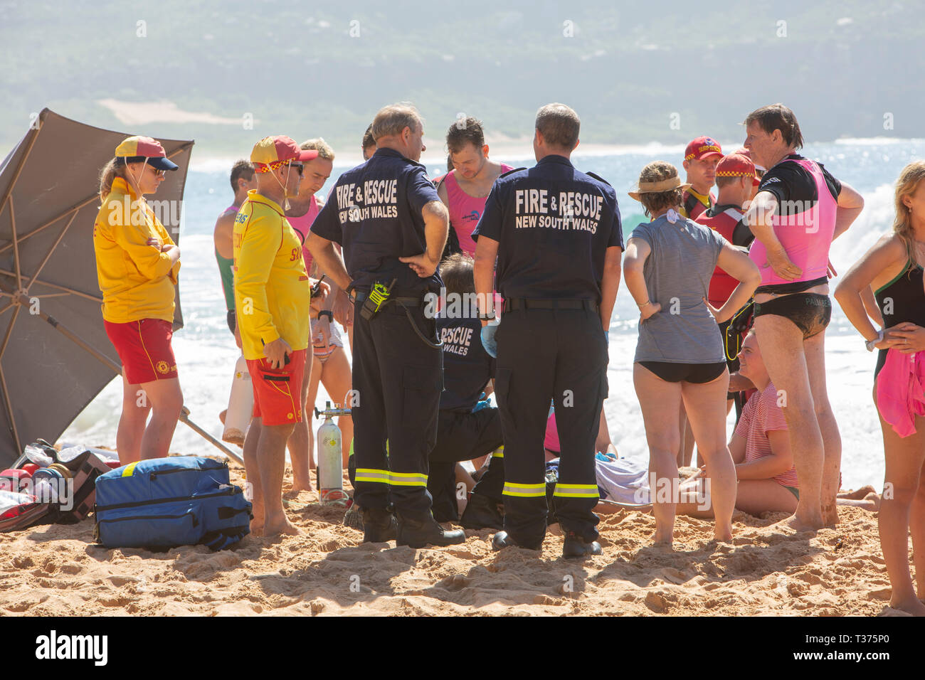 man rock fishing was rescued and feared drowned at Palm Beach Sydney, surf rescue lifeguards and others provide oxygen and CPR until ambulance arrive. Stock Photo