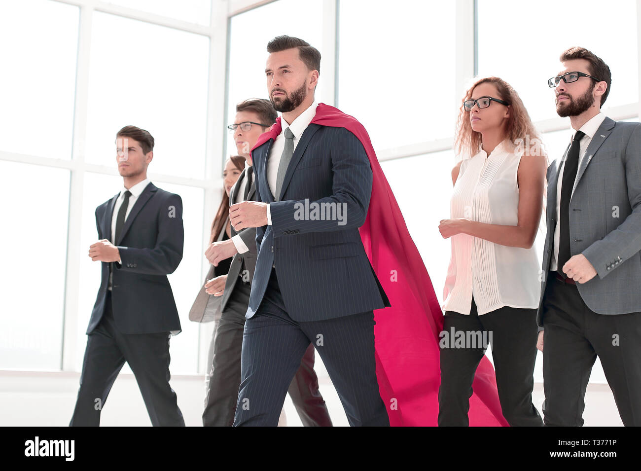 businessman in Superman cloak and business team standing in office ...