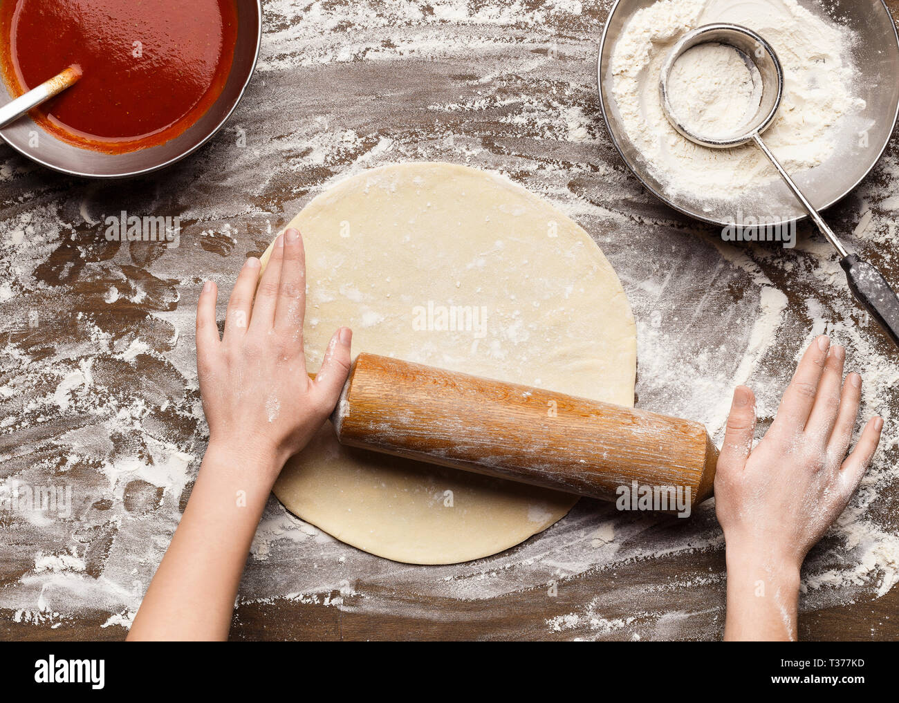 Chef rolling dough for pizza on table, top view Stock Photo