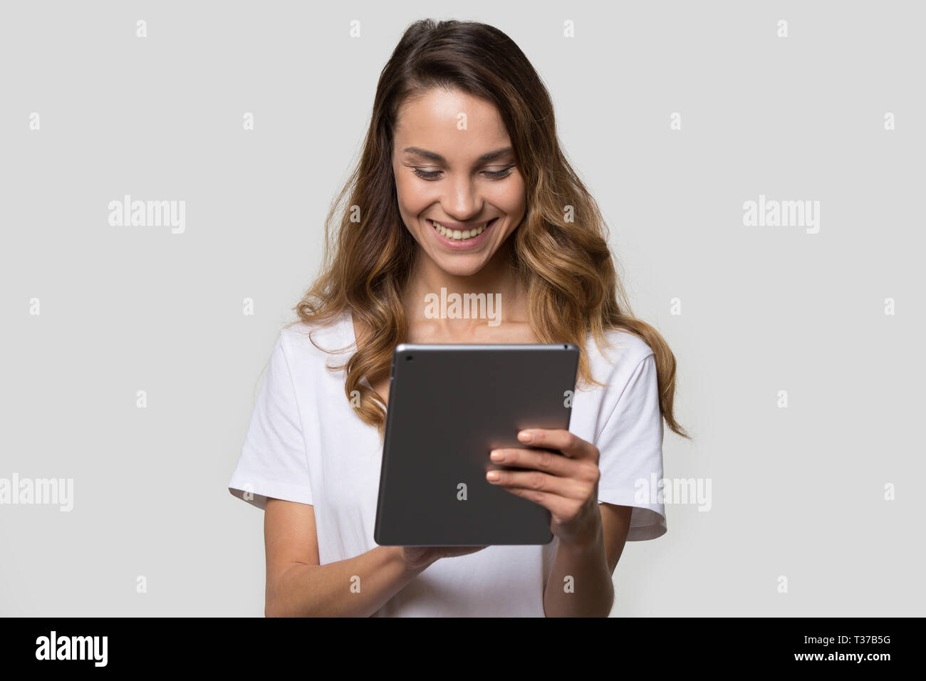 Woman using gadget looking at digital tablet screen studio shot Stock Photo