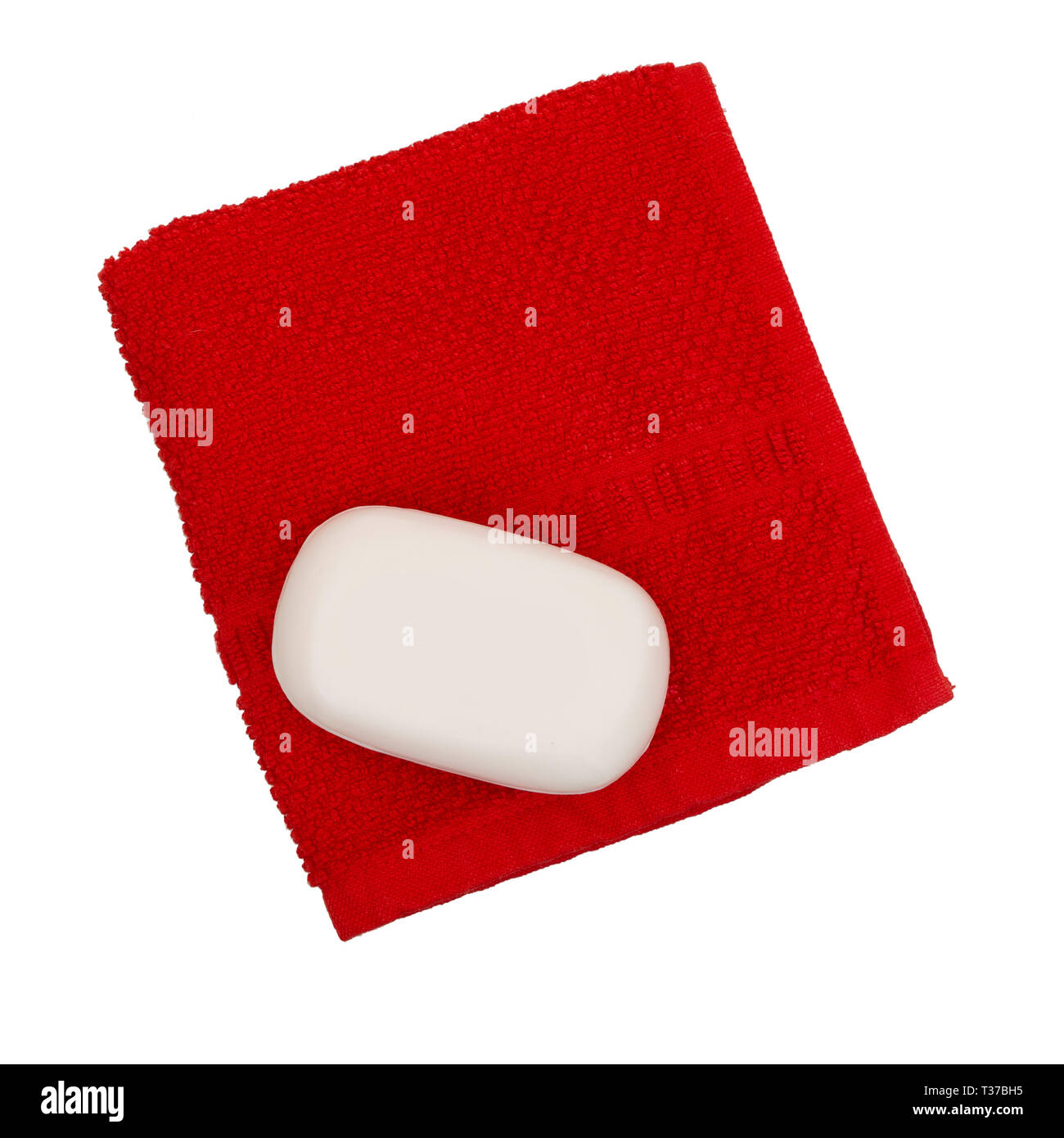 Simple white soap on red face flannel, facecloth, isolated on white background. Health, hygiene, environmentally friendly. Stock Photo