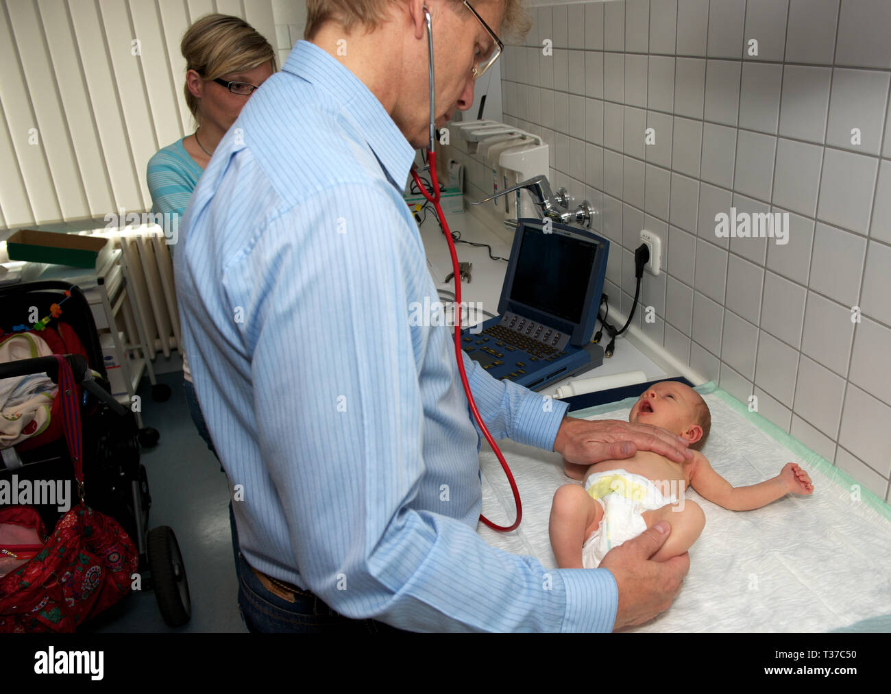 Doctor examining babies heart Stock Photo