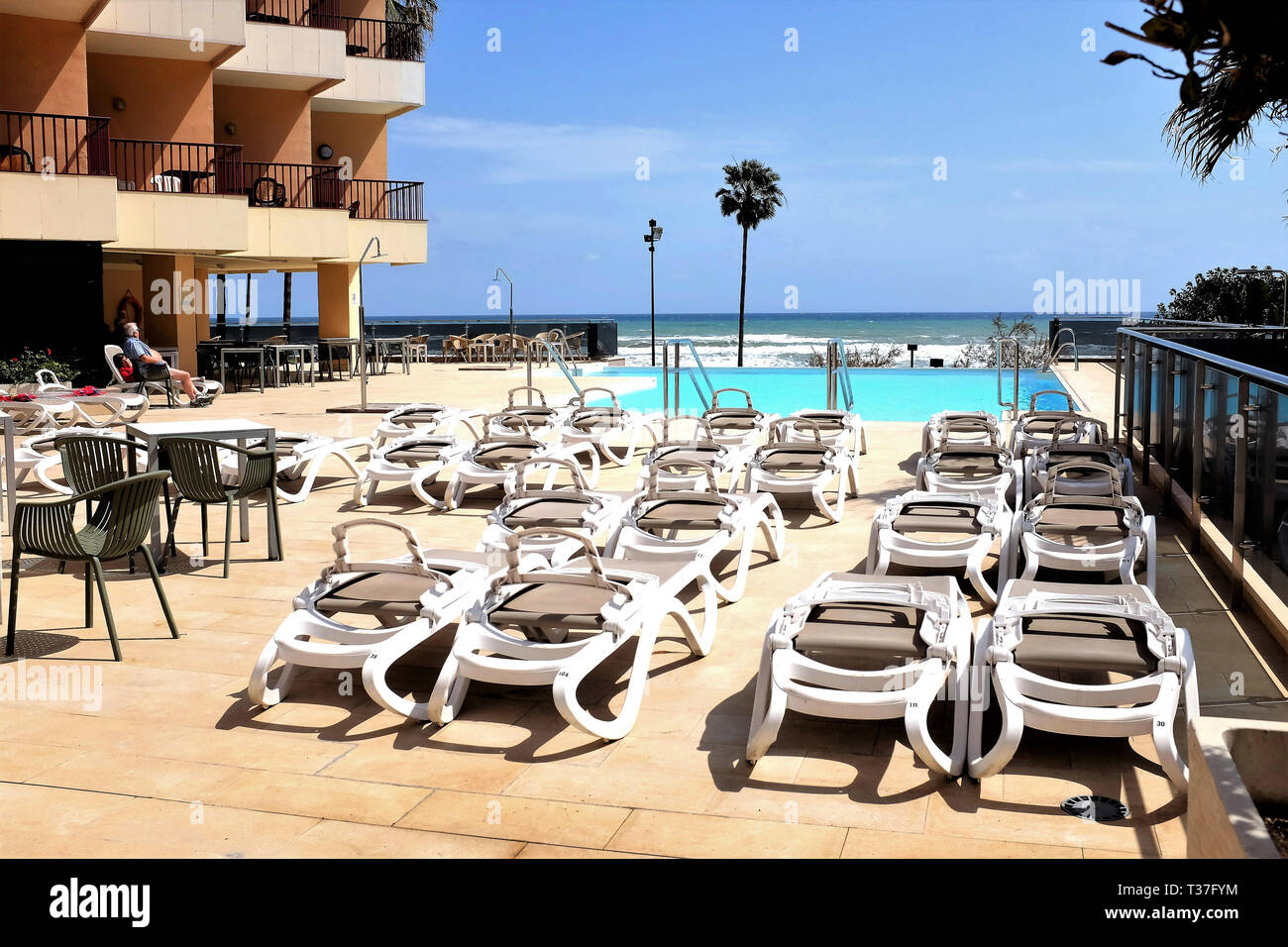 Fuengirola, Costa del Sol, Spain. March 29, 2019. Holidaymakers enjoying the sun and view beside the infinity swimming pool looking towards the sea. Stock Photo