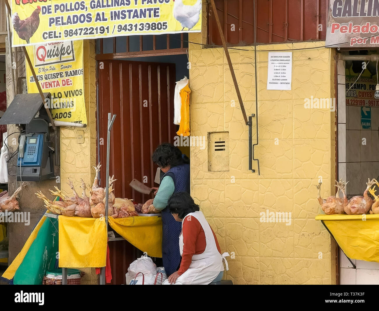 CUSCO, PERU- JUNE 20, 2016: a woman chops up chicken at a street side shop in cusco, peru Stock Photo