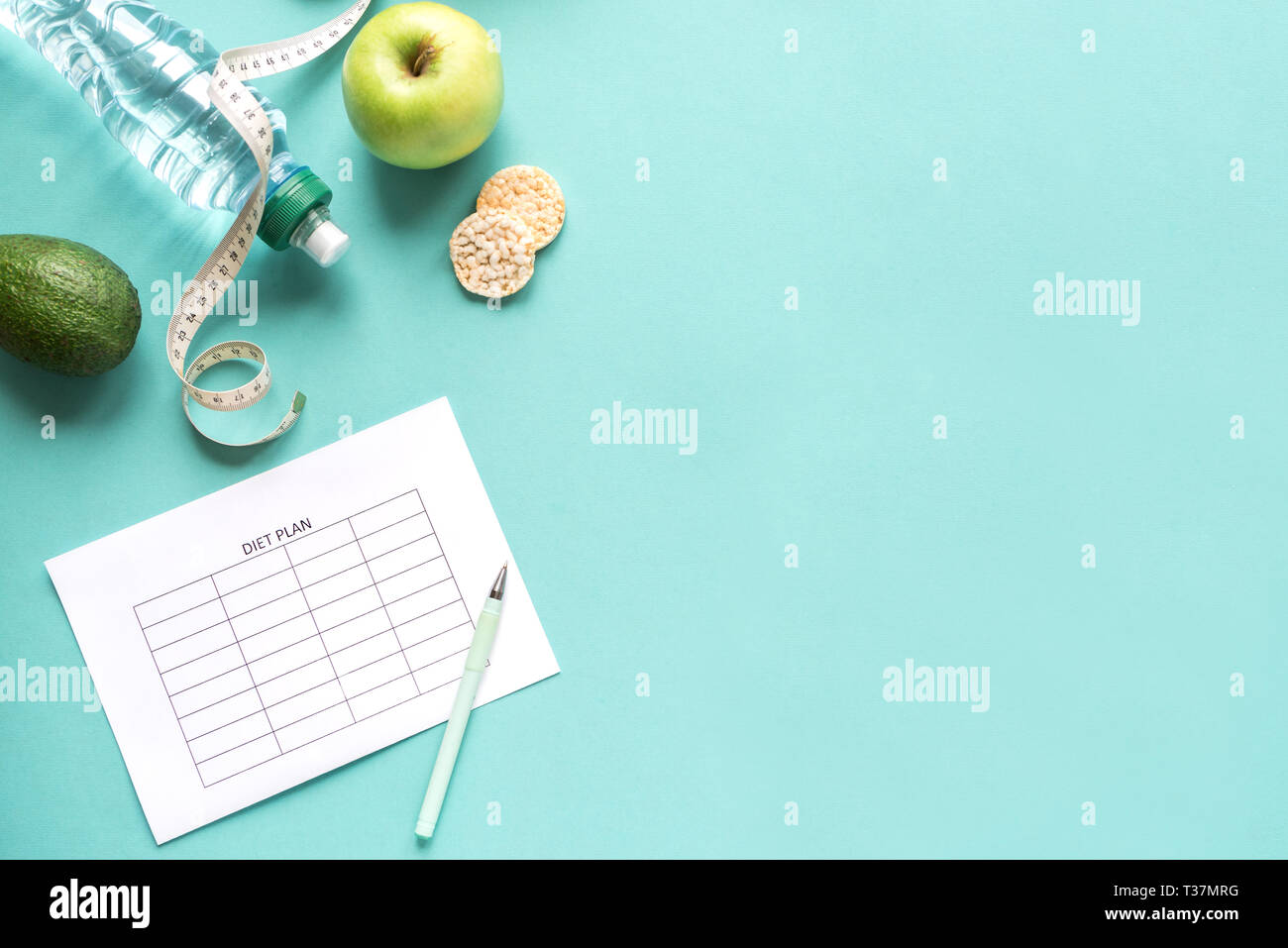Diet meal plan mockup with water, fruits and measuring tape. Fitness nutrition, diet concept on blue, top view, copy space. Stock Photo
