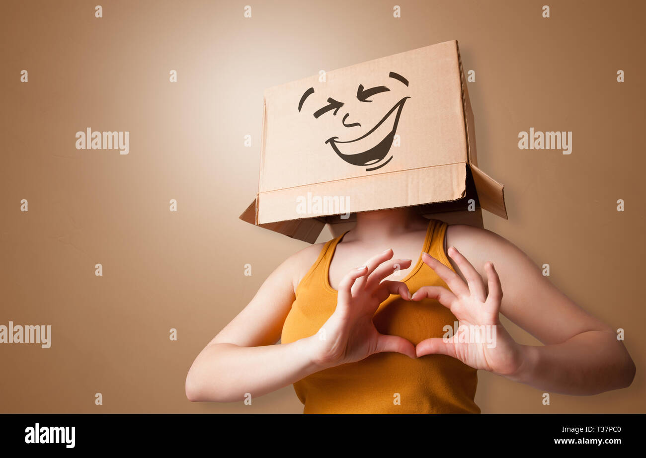 Young girl standing and gesturing with a cardboard box on her head