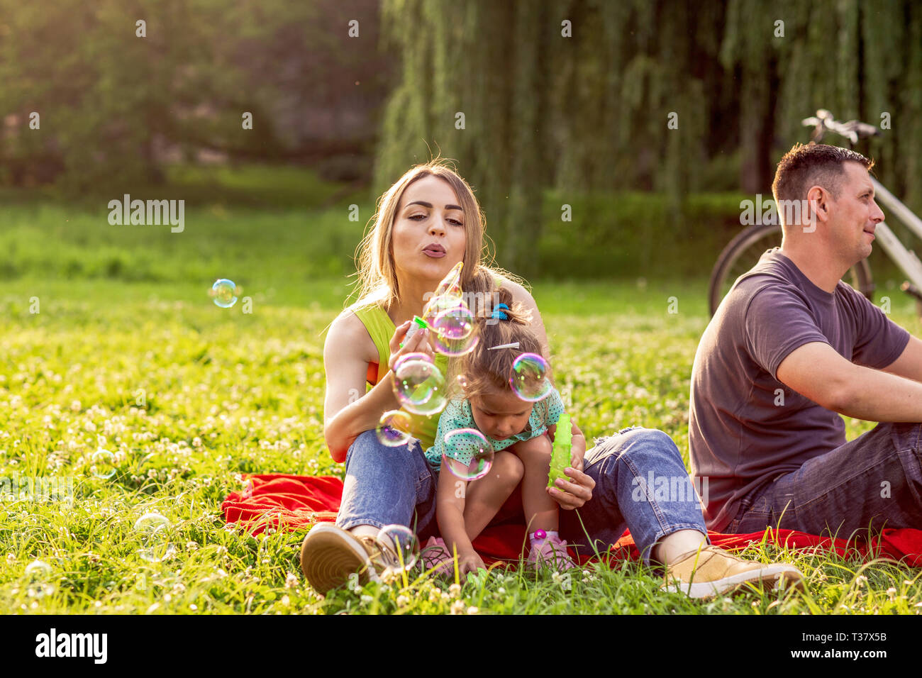 happy family mother and child daughter blow soap bubbles in park Stock ...