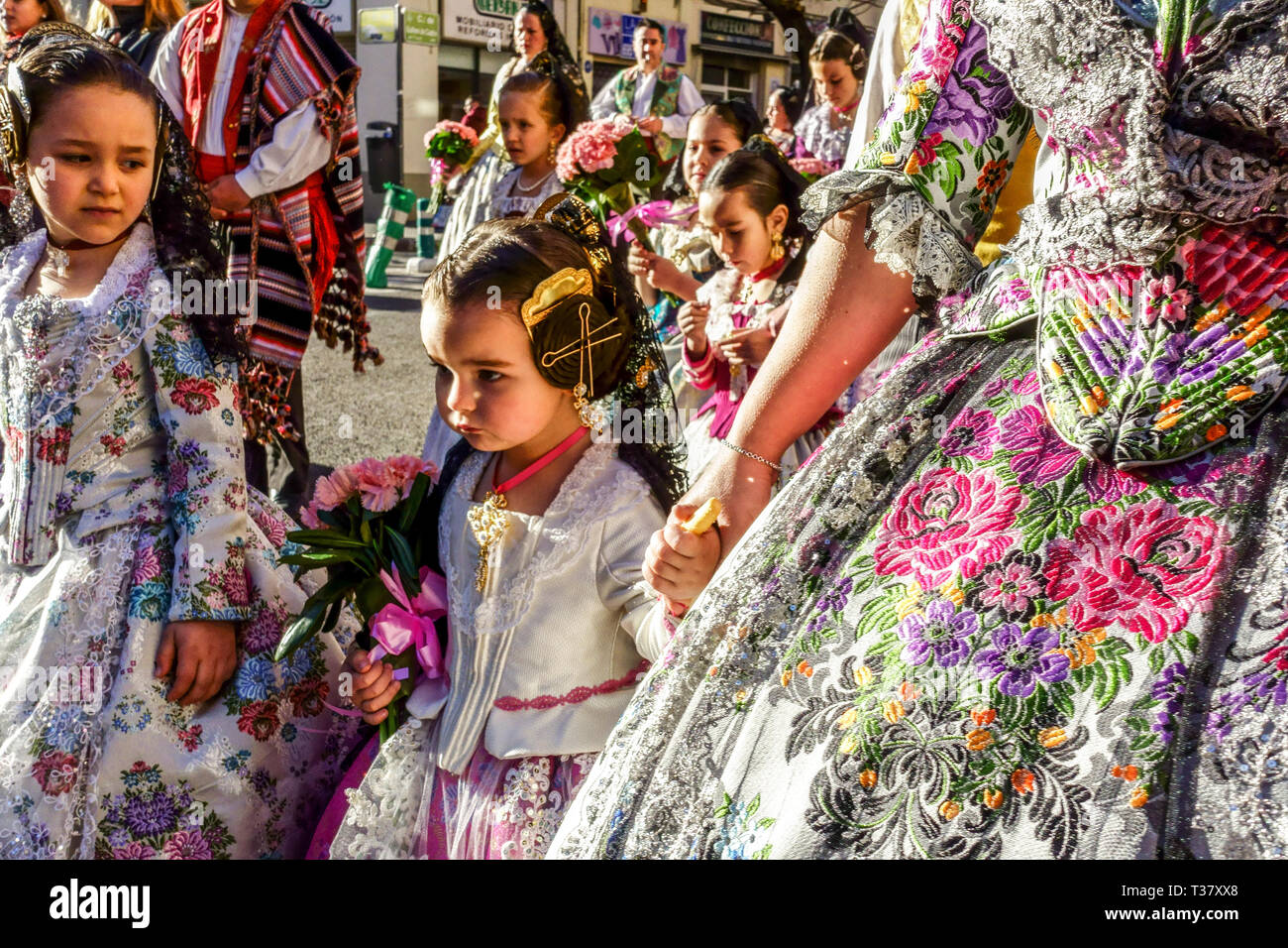 Fallas festival Valencia, People, Kids, Children girls dressed in traditional dress colorful costumes marching to Virgen, Spain Europe Las Fallas Stock Photo