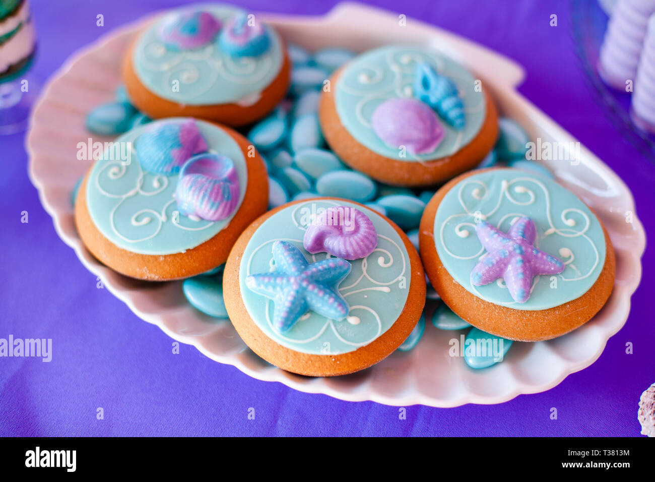 White Shell Plate Full Of Chocolate Candies With Blue Icing Cookies With Shells Stars On The Table With Shining Cloth Summer Season Delicious On Th Stock Photo Alamy
