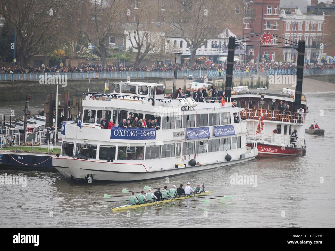 London, UK. 7th April, 2019. The annual Boat Race between Oxford and Cambridge University crews takes place on the 6.8 km River Thames Championship Course from Putney to Mortlake. Image: Cambridge Mens Blue Boat Crew: Dave Bell, James Cracknell, Grant Bitler, Dara Alizadeh, Callum Sullivan, Sam Hookway, Freddie Davidson, Natan Wegrzycki-Szymczyk (Stroke), Matthew Holland (Cox), making their way downstream before race start and passing crowds lining Putney riverside. Credit: Malcolm Park/Alamy Live News. Stock Photo