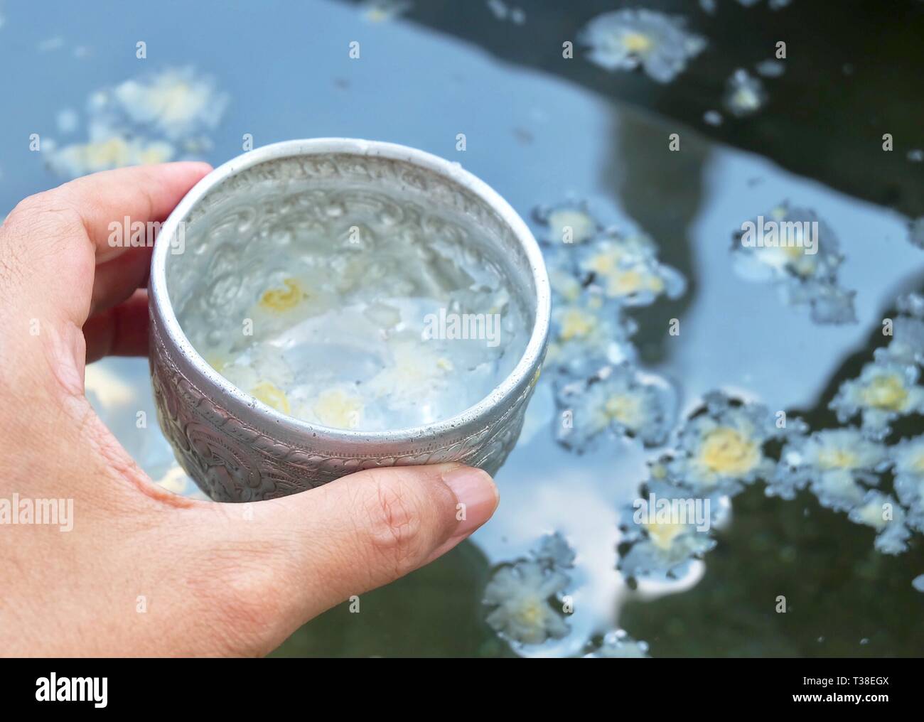 Buddhist Hand Holding A Small Bowls with Holy Water or Blessed Water
