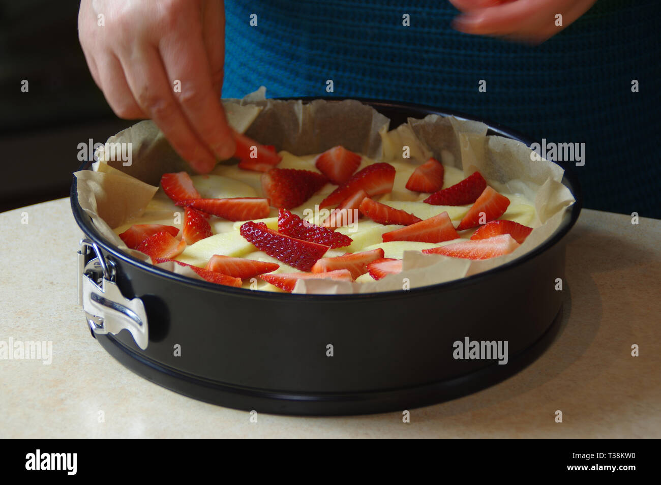 Preparing yeast cake with apple and strawberry to baking. Fresh raw homemade fruit pastry. Stock Photo