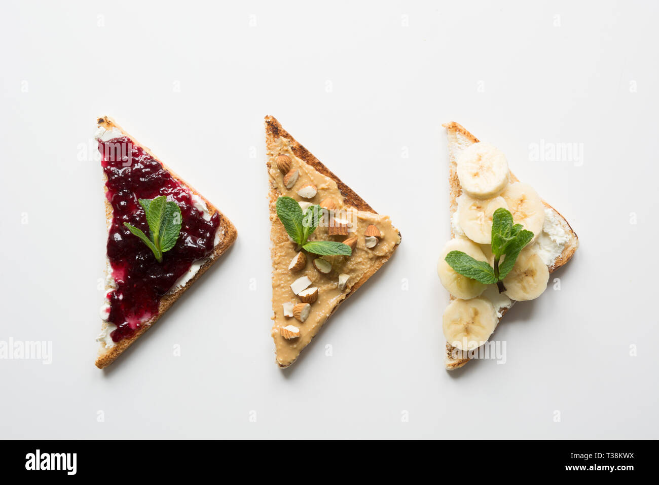 Different types of sandwiches for healthy children's breakfast without sugar, with nut paste, bananas, berry jam. View from above. Stock Photo