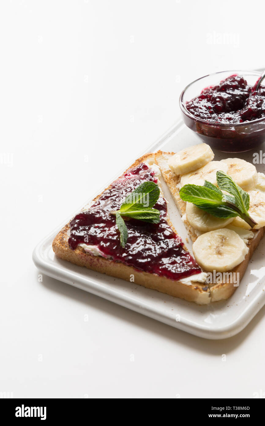 Different types of sandwiches for healthy children's breakfast without sugar, with berry jam, bananas.Space for text. Close sup. Stock Photo