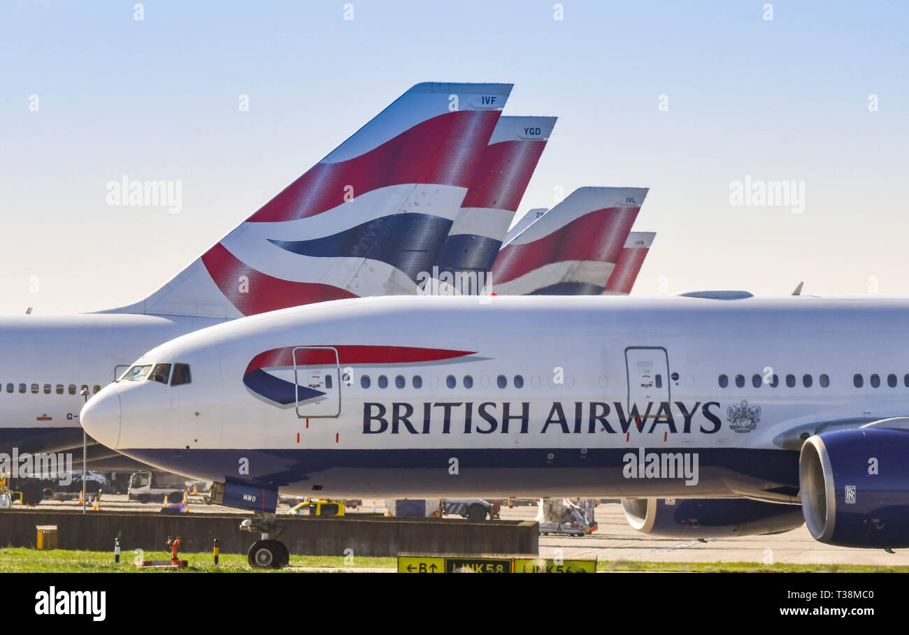 LONDON, ENGLAND - MARCH 2019: Boeing 777 long haul airliner operated by British Airways taxiing for take off at London Heathrow Airport past tail fins Stock Photo