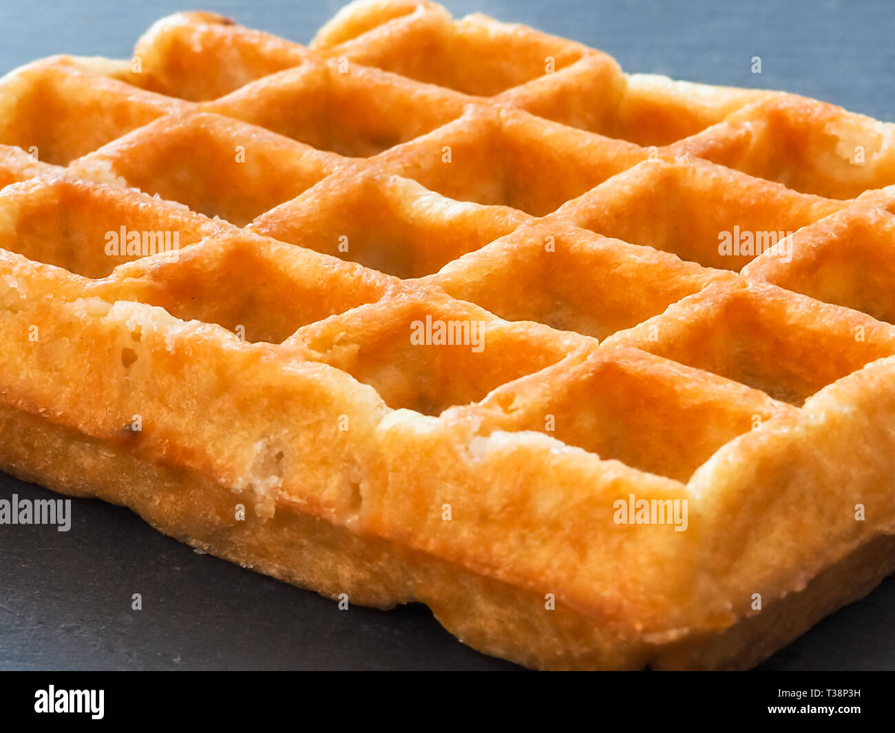 A Belgian waffle on a slate plate Stock Photo