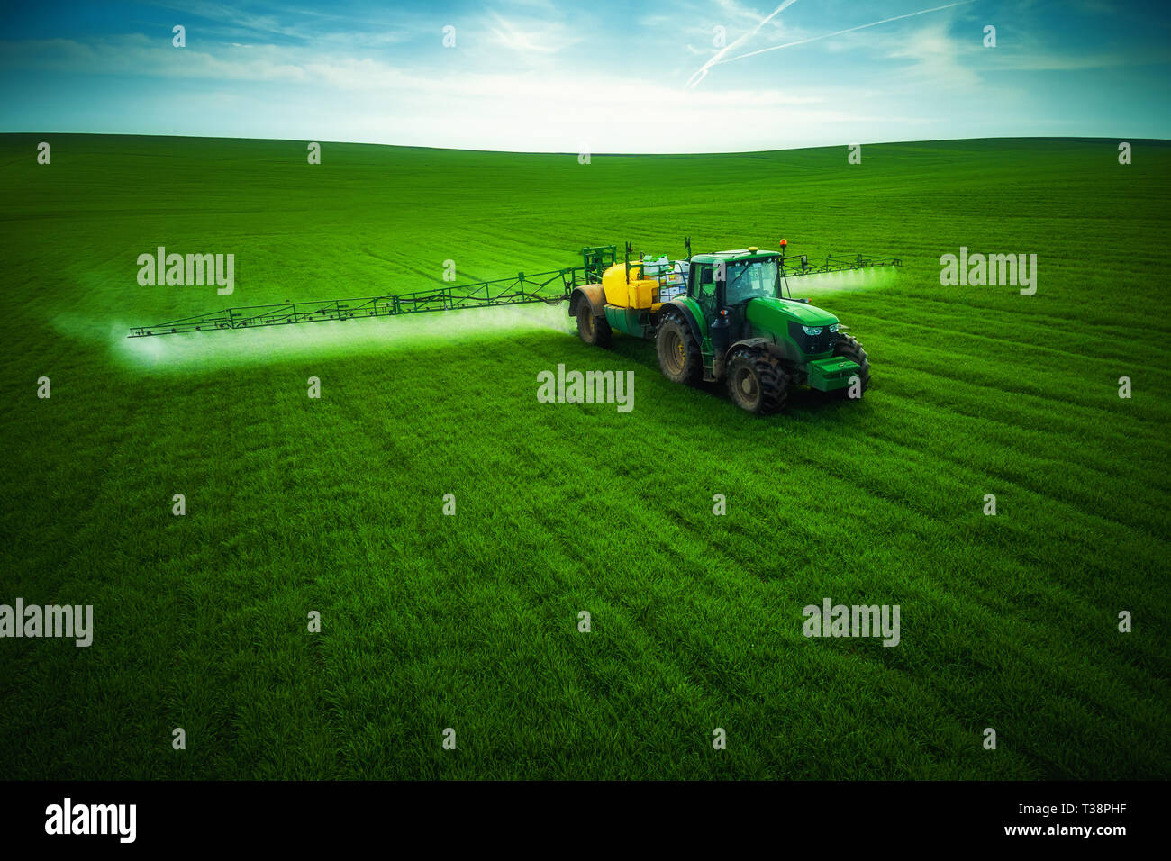 Aerial view of farming tractor plowing and spraying on field Stock ...