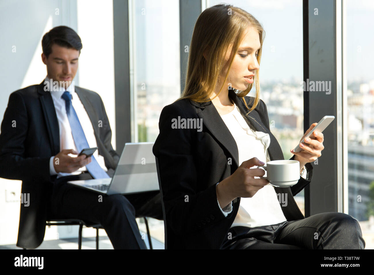 Young workers having break at office and resting near window Stock Photo