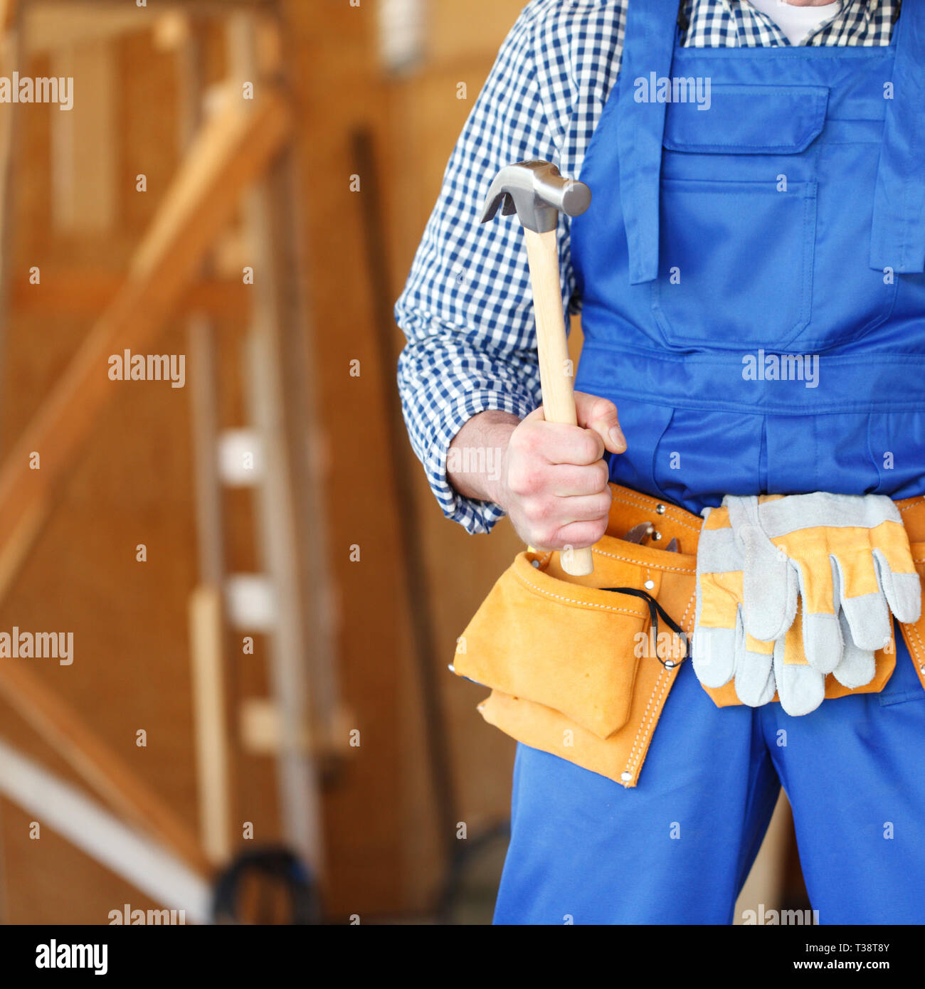 Construction worker at construction site holding hammer Stock Photo - Alamy